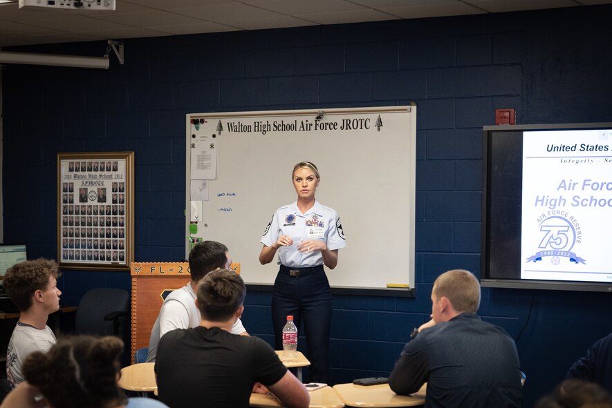 A female Air Force recruiter speaks to cadets in a classroom
