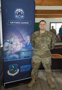 Staff Sgt. Trevor LaPierre, 158th Maintenance Squadron, poses for a photo at the Vermont Air National Guard base in South Burlington, Vermont, March 8, 2023. LaPierre is the official Air Force Gaming Base Ambassador for the 158th Fighter Wing and assisted in organizing the first Air Force Gaming event for the wing to participate in.