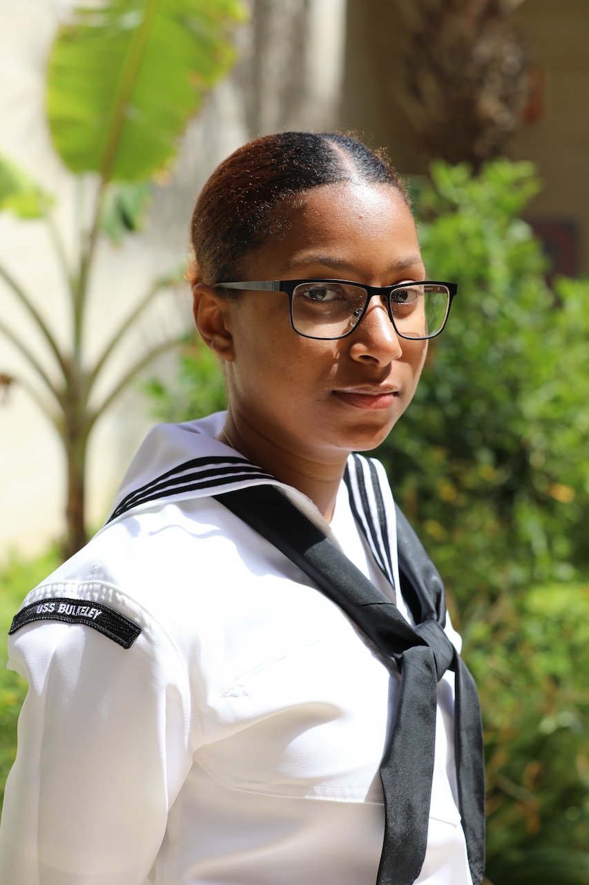 (March 20, 2023) Culinary Specialist Seaman Apprentice Erica Lopes, assigned to the guided missile destroyer USS Bulkley (DDG 84), poses for a photo following the opening ceremony of the African Maritime Forces Summit (AMFS), Mar. 20 2023. Lopes, a Boston native, immigrated from Cabo Verde as a child and returned for the first time during AMFS. Hosted by NAVEUR-NAVAF, the AMFS is a strategic-level forum that brings African maritime and naval infantry leaders together with their international partners to address transnational maritime security challenges within African waters including the Atlantic Ocean, Indian Ocean, and Mediterranean Sea.