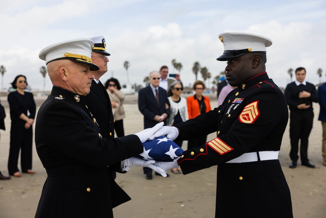 U.S. Marine Staff Sgt. Joe Williams, right, the staff noncommissioned officer in charge of the color guard with Headquarters and Support Battalion, Marine Corps Base Camp Pendleton, Marine Corps Installations - West, passes off a folded U.S. flag to retired Col. Willard Buhl as part of a memorial service for retired Lt. Col. Clark Henry on Marine Corps Base Camp Pendleton, California, Feb. 21, 2023. Henry enlisted during World War II, received a field commission during the Korean War and received a Silver Star during the Vietnam War. The memorial service included a tour of the 1st MARDIV command post, a tour of Camp Pendleton’s Landing Vehicle Tracked Museum and the release of Henry’s ashes at Del Mar Beach.