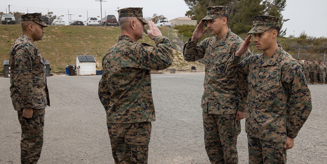 U.S. Marine Corps Cpl. Christopher J. Parris, and Lance Cpl. Elijah Serrano, both motor transport operators, with Combat Logistics Battalion 1, 1st Marine Logistics Group, I Marine Expeditionary Force, salute Brig. Gen. Phillip N. Frietze, commanding general, 1st Marine Logistics Group, on Camp Pendleton, California, Mar. 10, 2023. Parris and Serrano were awarded for providing a series of tasks to support lifesaving actions while he personally provided multiple rounds of cardiopulmonary resuscitation. (U.S. Marine Corps photo by Sgt. Aldo Sessarego)