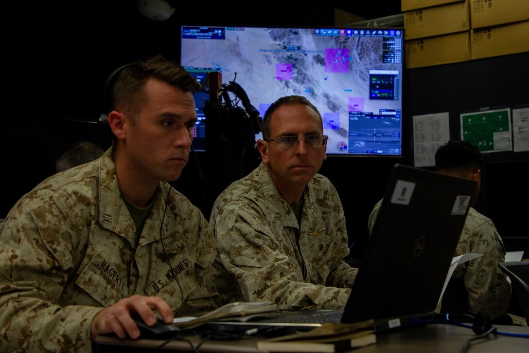 U.S. Marine Corps Capt. Joseph Hagerty, left, and Capt. Paul Kelly, forward air controllers with Tactical Training and Exercise Control Group navigate a virtual battlespace at the Battle Simulation Center (BSC), Marine Corps Air Ground Combat Center, Twentynine Palms, Nov 8, 2022. The BSC has developed virtual training technology in conjunction with the Office of Naval Research to train Joint Tactical Air Controllers and Forward Air Controllers more safely, more economically, and in a more realistic environment. (U.S. Marine Corps photo by Cpl. Jonathan M. Forrest)