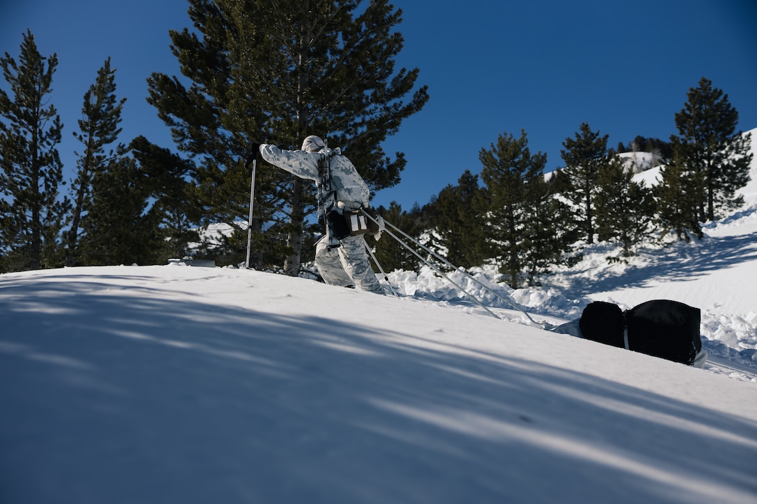 A U.S. Marine with 3rd Battalion, 2nd Marine Regiment, 2nd Marine Division, pulls a Marine Corps Cold Weather Infantry Kit up a hill during Mountain Warfare Training Exercise (MTX)