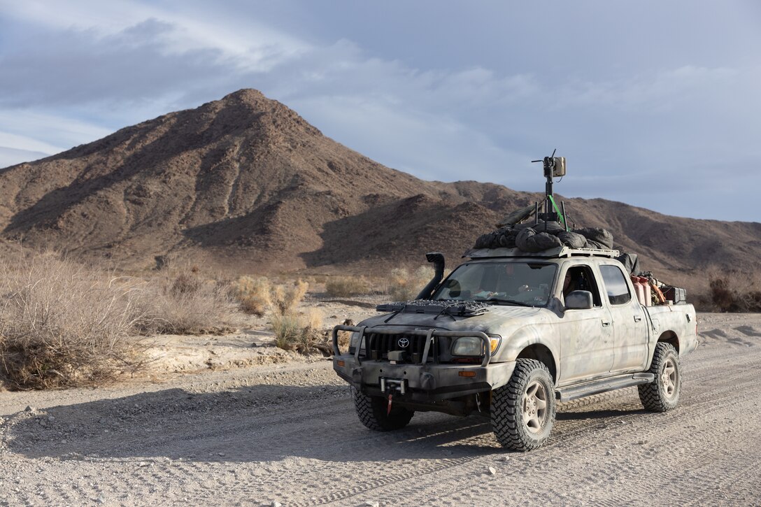 A civilian contractor drives a Toyota Tacoma over to an HDT Hunter WOLF for transport during Marine Air-Ground Task Force Warfighting Exercise (MWX) 2-23, at Marine Corps Air Ground Combat Center, Twentynine Palms, California, Feb. 23, 2022. MWX is the culminating event of Service Level Training Exercise 2-23, that improves U.S. and allied service members’ operational capabilities. (U.S. Marine Corps photo by Cpl. Andrew Bray)