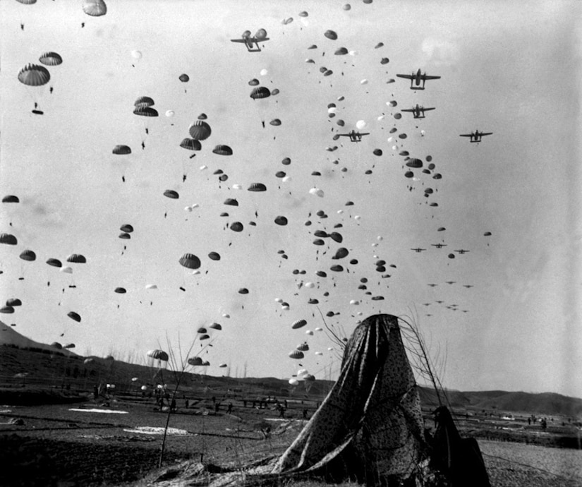Paratroopers of the 187th Airborne Regimental Combat Team (RCT), the 2d and 4th Ranger Companies, and the Indian Army Parachute Field Ambulance unit jump into combat at Munsan-Ni, Korea, 23 March 1951.  (National Archives)