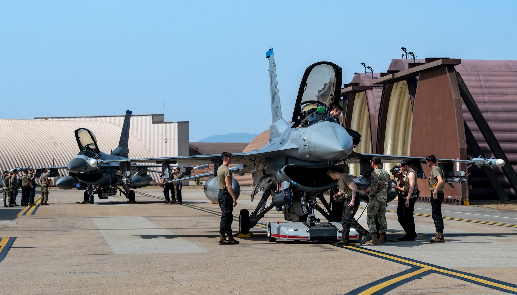 U.S. Air Force Airmen assigned to the 35th Fighter Generation Squadron, Kunsan Air Base, prepare to tow F-16 Fighting Falcons at Osan AB, Republic of Korea, March 22, 2023.