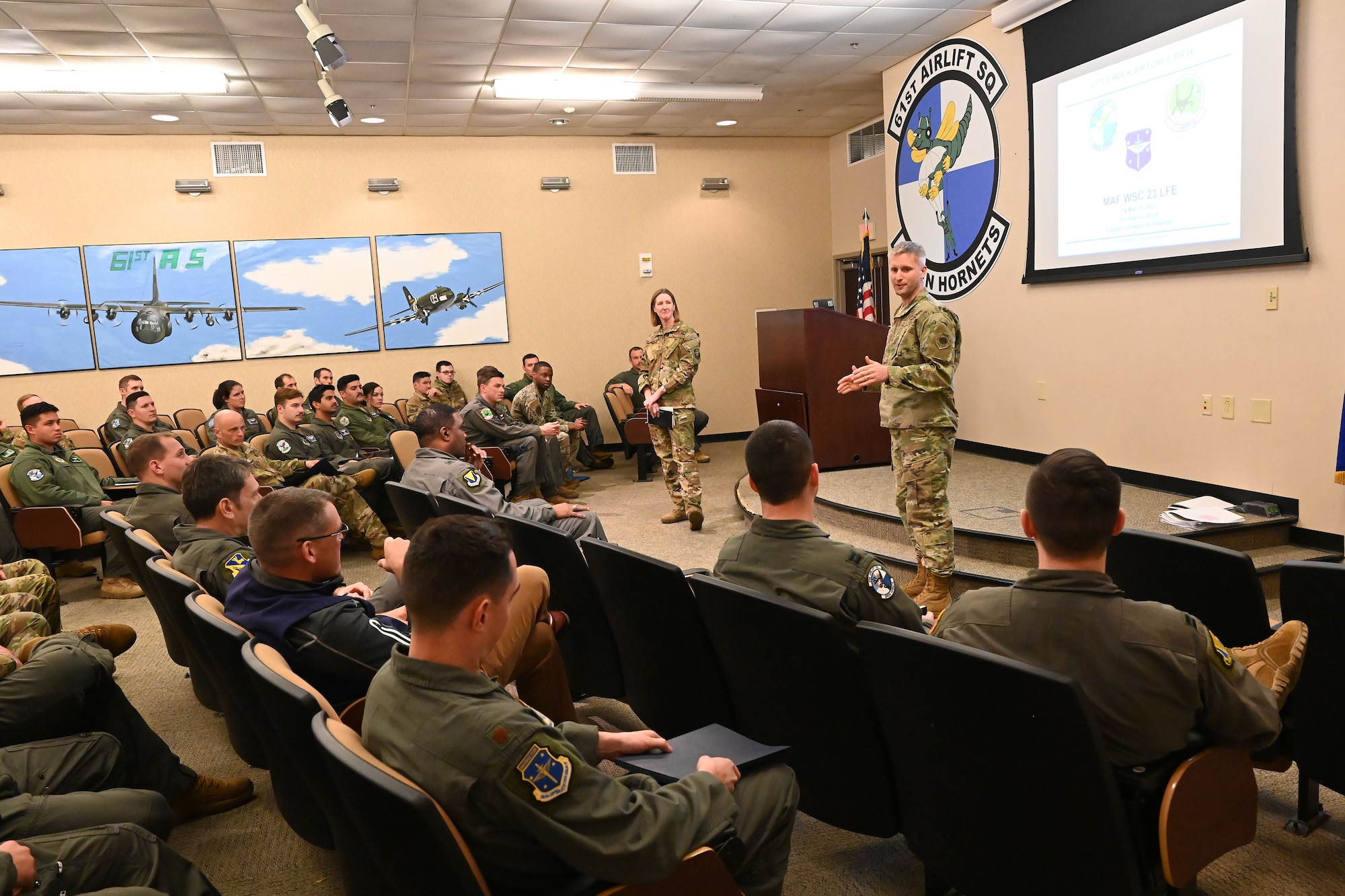 airmen receive a briefing in an auditorium