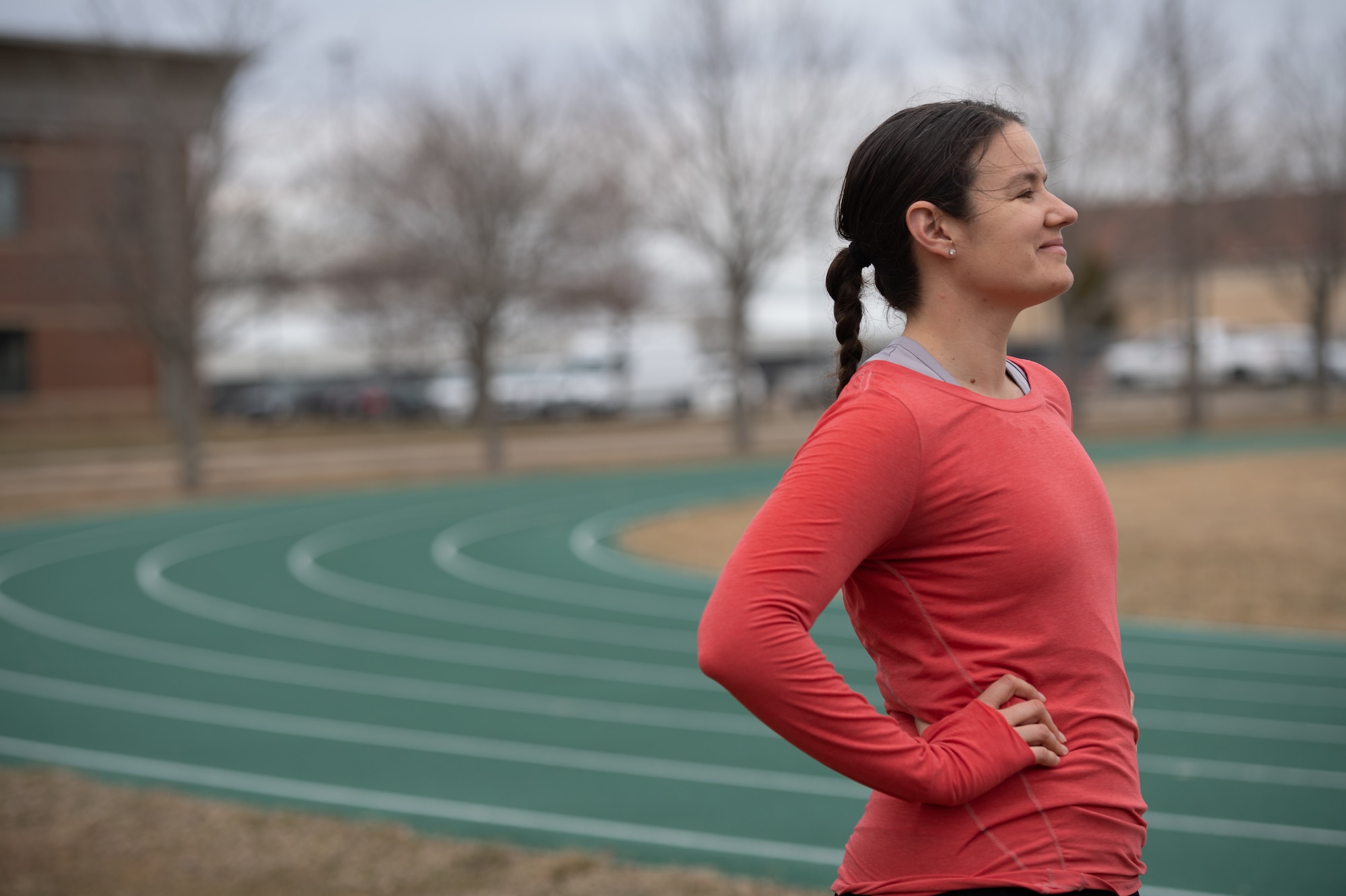 Maj. Jenifer Mouser stands outside with the green track in the background