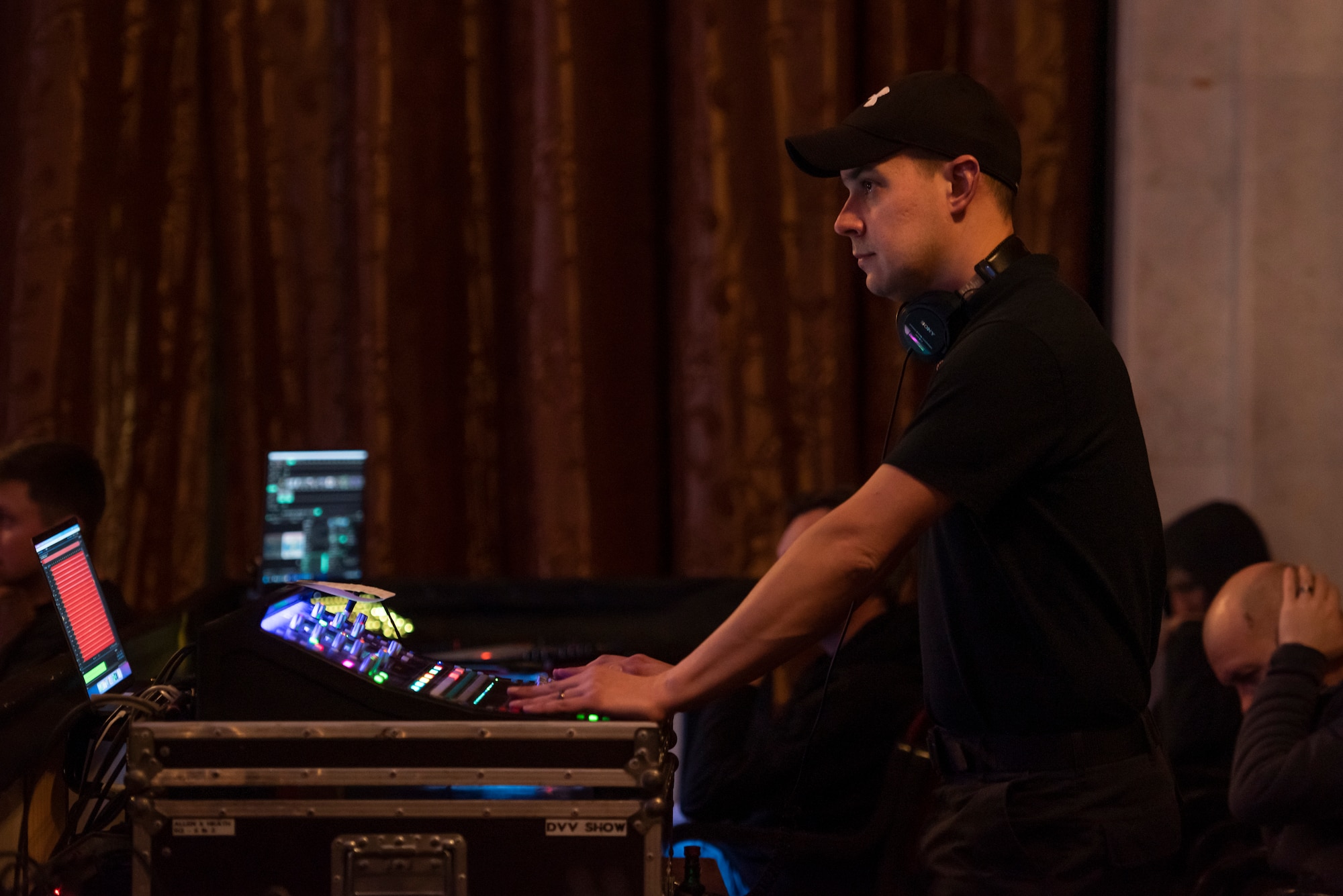 A man changes levels on a sound board