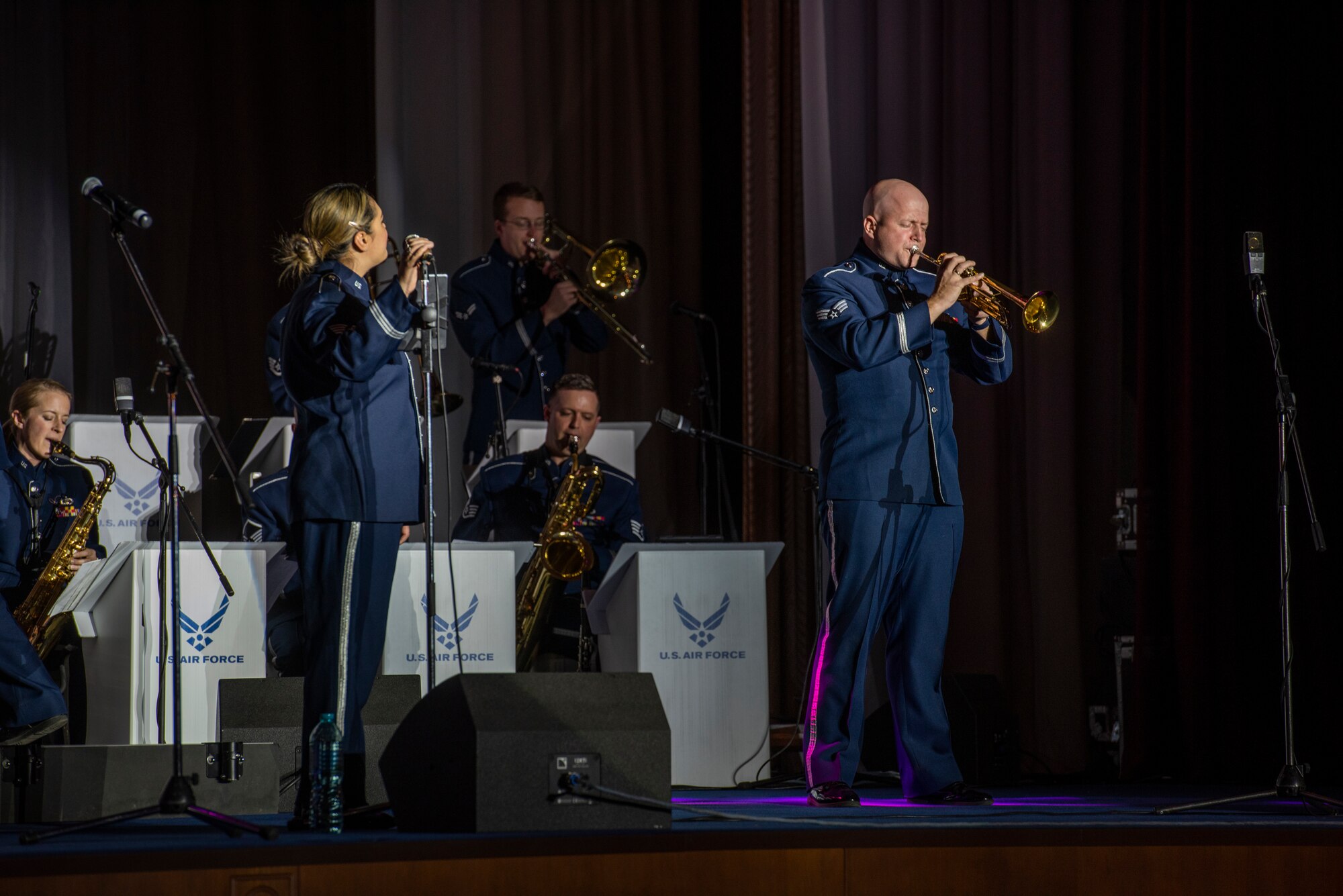 A man plays a trumpet on a stage