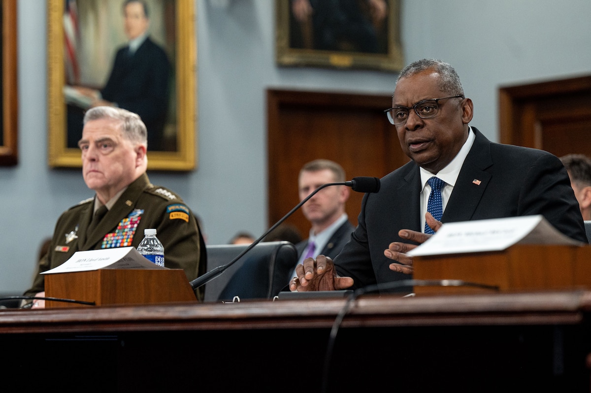 Secretary of Defense Lloyd J. Austin III and Army Gen. Mark A. Milley sit at long table.