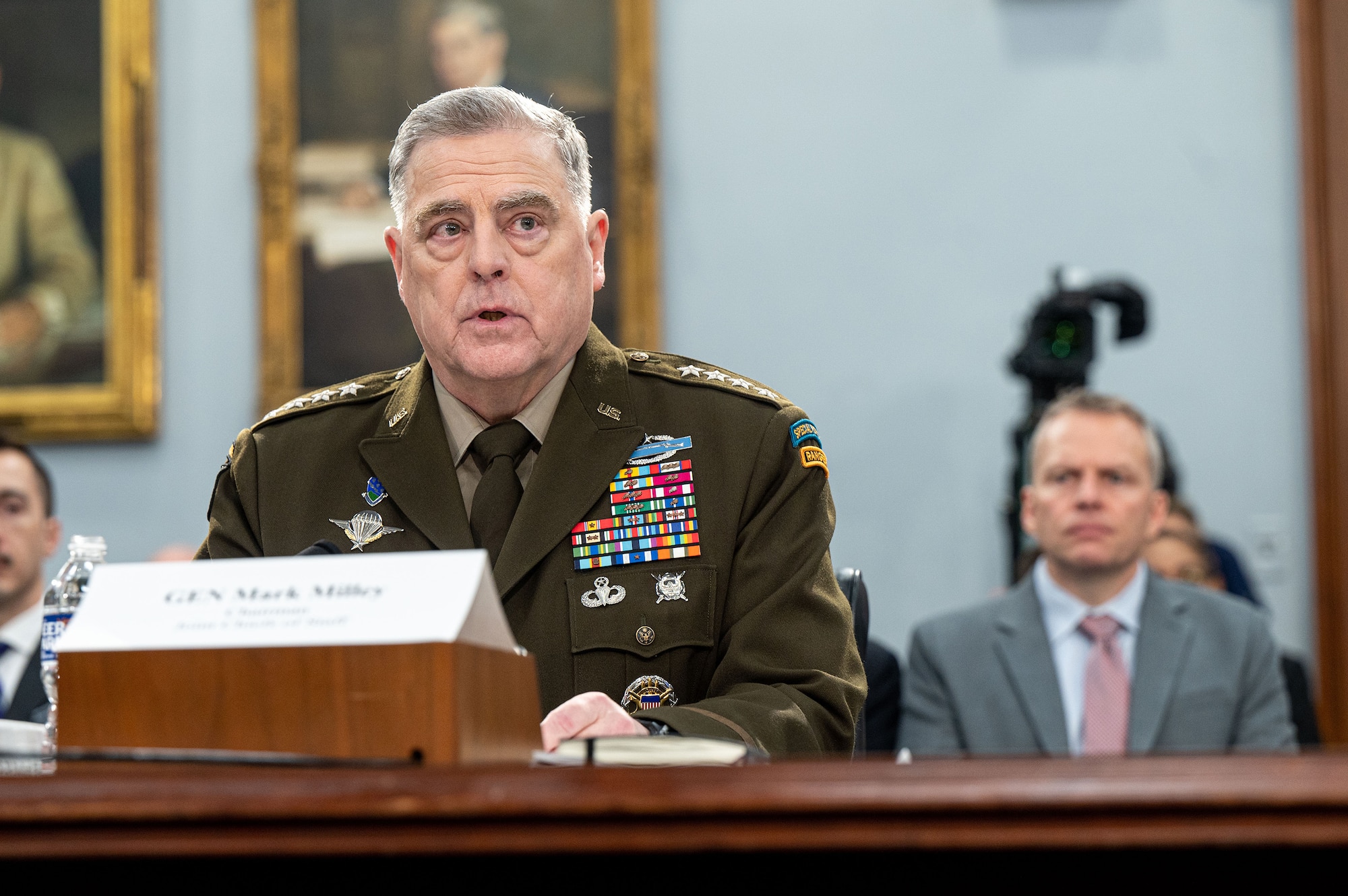 Army Gen. Mark A. Milley sits and speaks at a table.