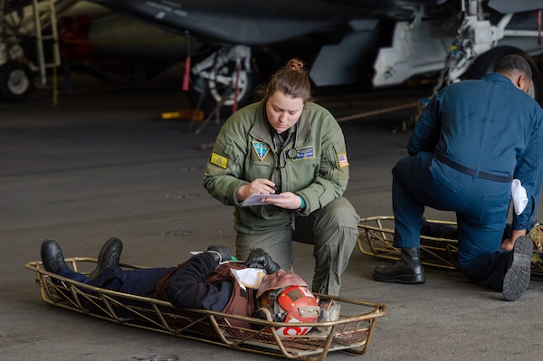 t. Hayley Hatherly assesses a simulated patient in the hangar bay of aboard USS Carl Vinson (CVN 70) in the Pacific Ocean.