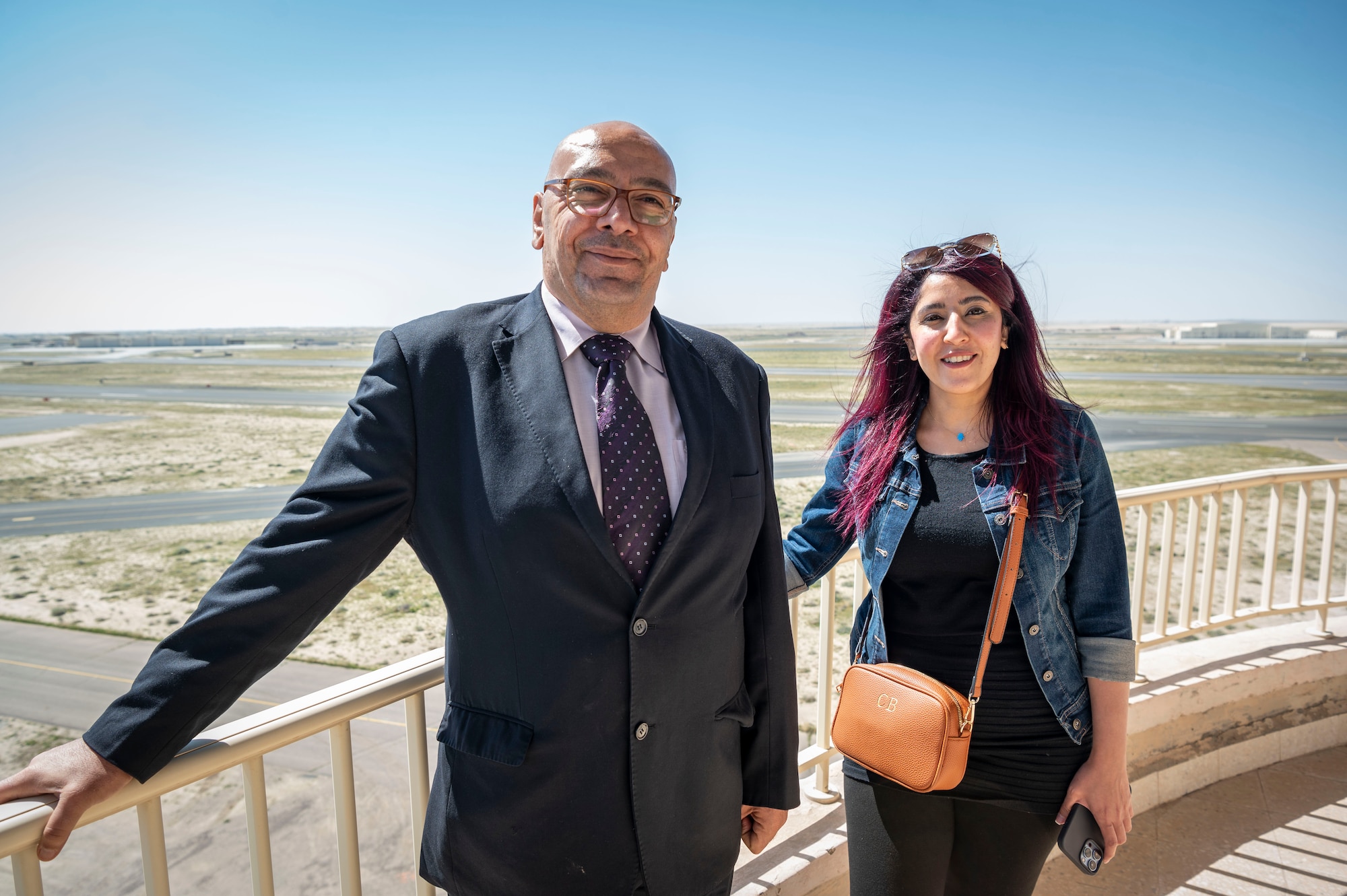 Mr. Osama Diab and Ms. Mai Alsoukari, Kuwaiti newspaper journalists, pose for a photo outside the air traffic control tower during Media Day at Ali Al Salem Air Base, Kuwait, March 21, 2023.