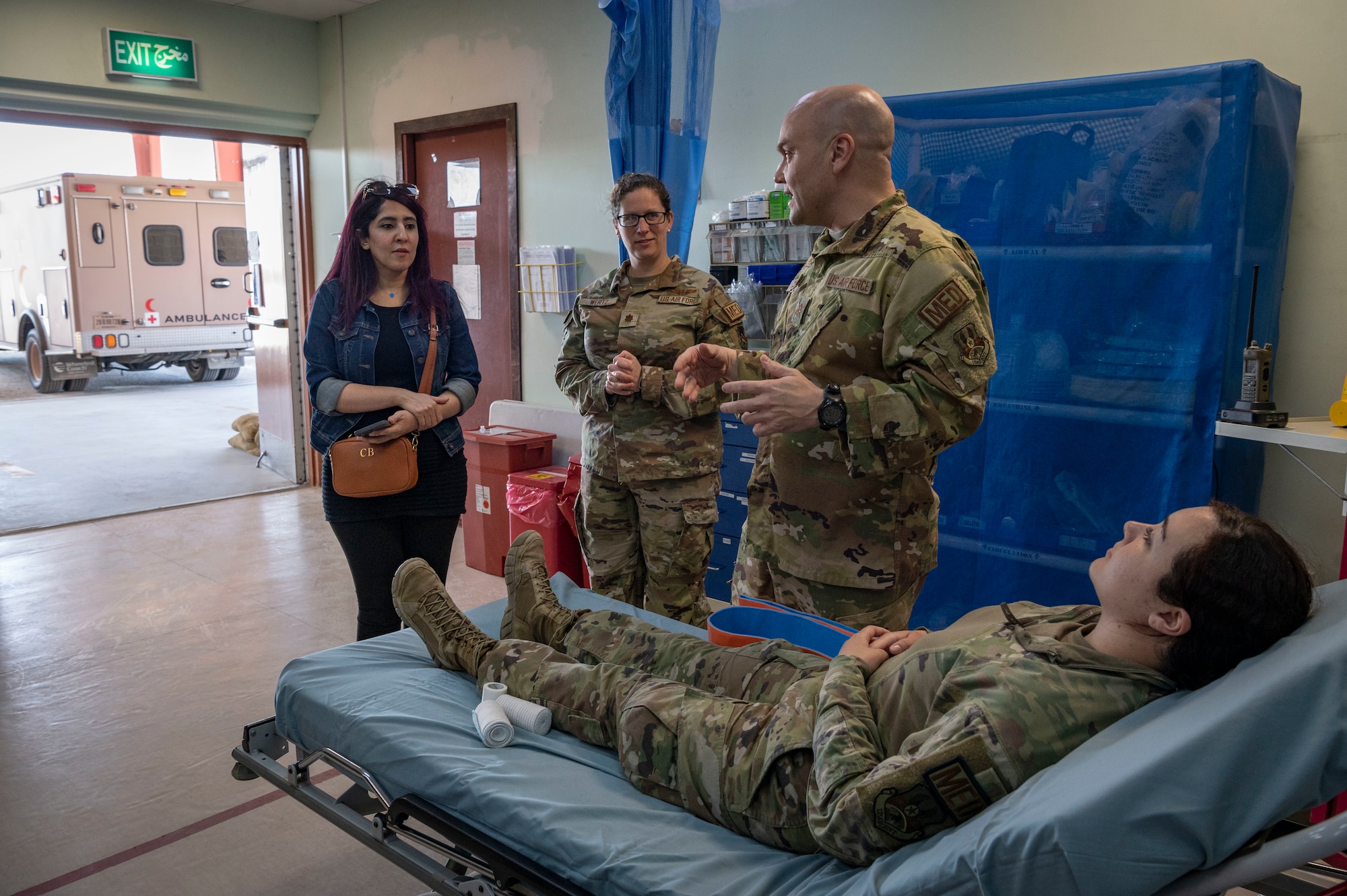 U.S. Air Force Maj. Jeremy Johnson and Maj. Maggie Wertz, 386th Expeditionary Medical Squadron physicians, explain how a splint works to Ms. Mai Alsoukari, a Kuwaiti newspaper journalist, before demonstrating how to use it during Media Day at Ali Al Salem Air Base, Kuwait, March 21, 2023.