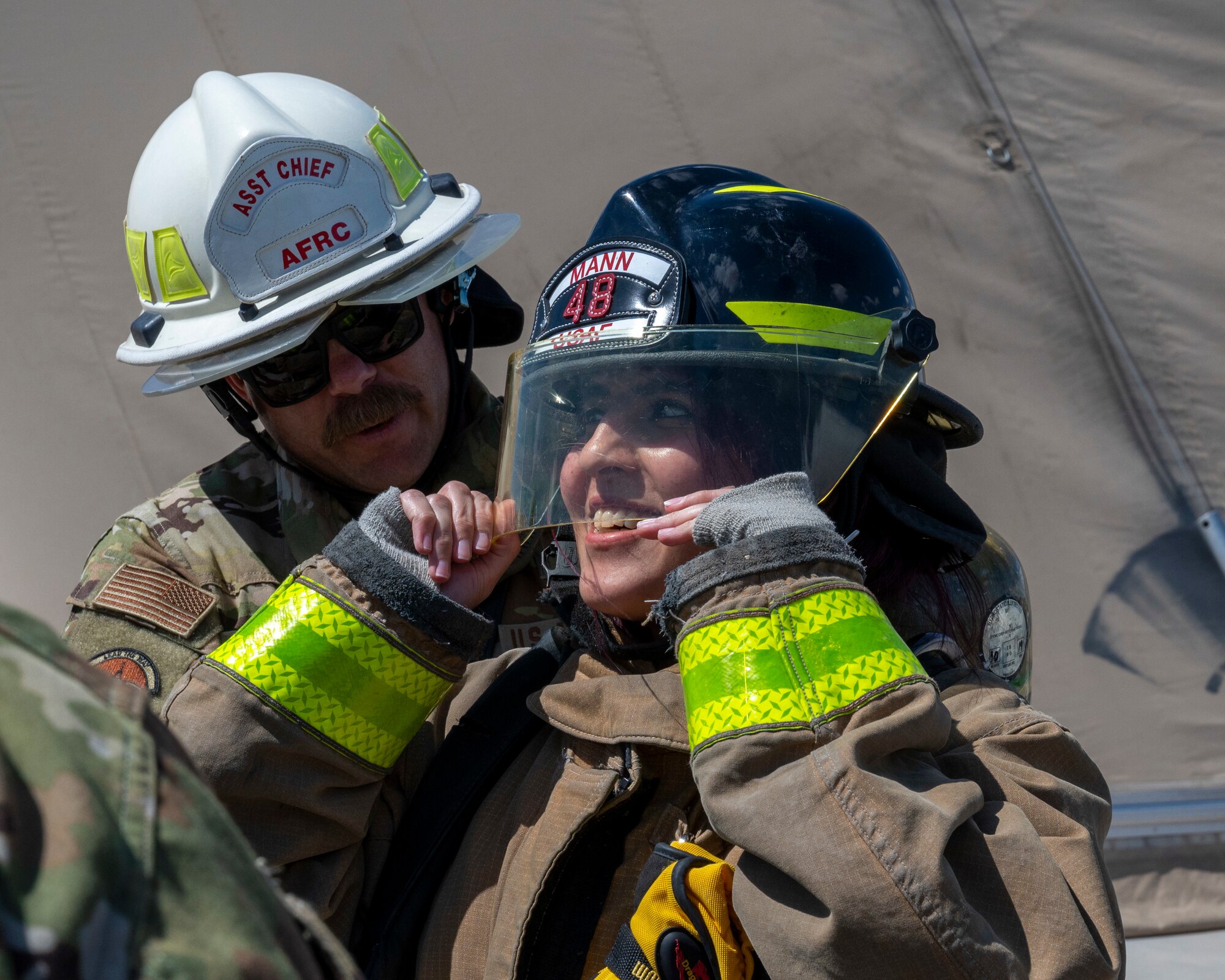 U.S. Air Force Master Sgt. Joseph Masiello, a 386th Expeditionary Civil Engineer Squadron assistant chief of operations, puts a firefighter suit on Mai Alsoukari, Al Qabas journalist, at Ali Al Salem Air Base, Kuwait, March 21, 2023.