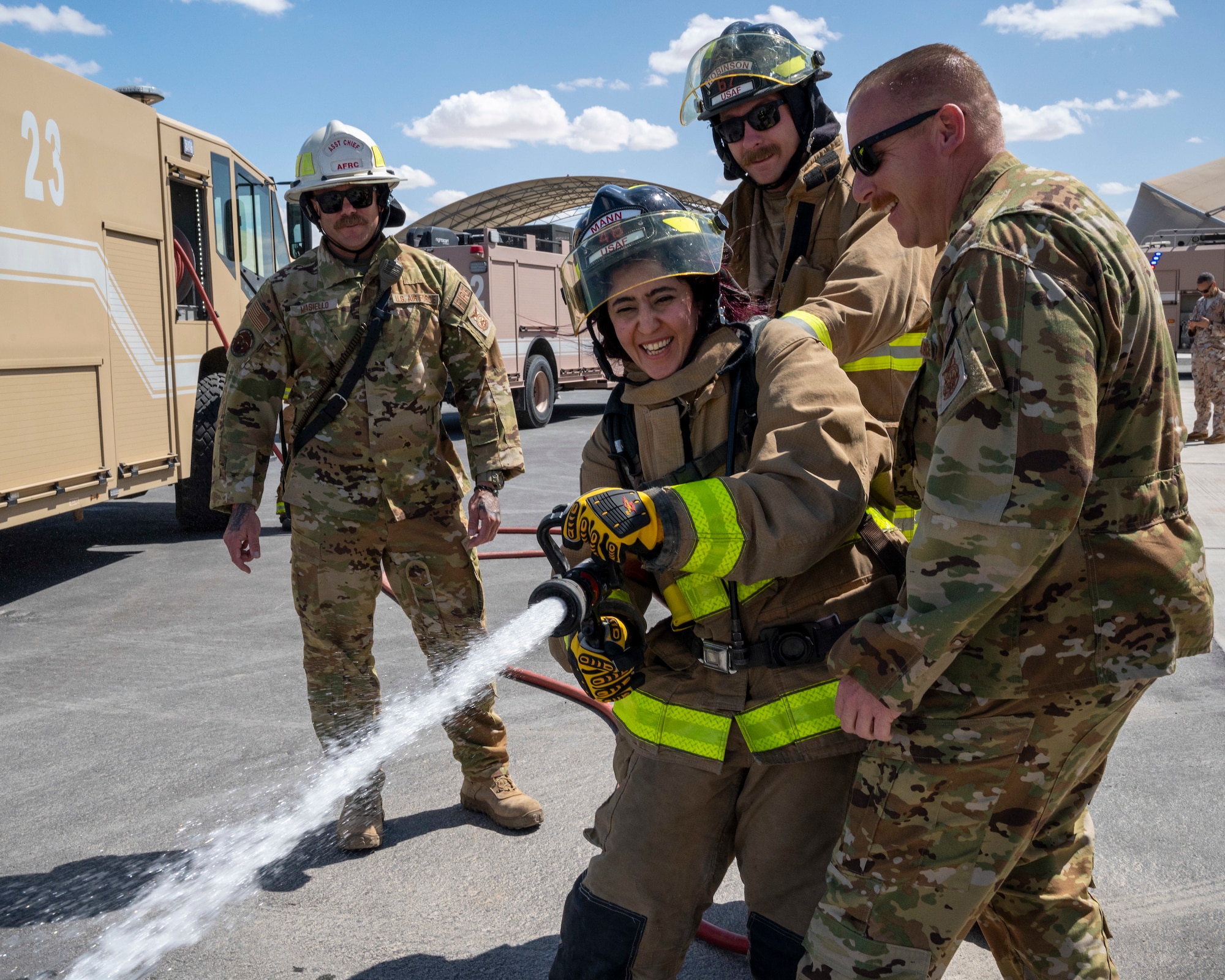 U.S. Air Force Firefighters from the 386th Expeditionary Civil Engineer Squadron help Mai Alsoukari, Al Qabas journalist, spray water from a firehose at Ali Al Salem Air Base, Kuwait, March 21, 2023.