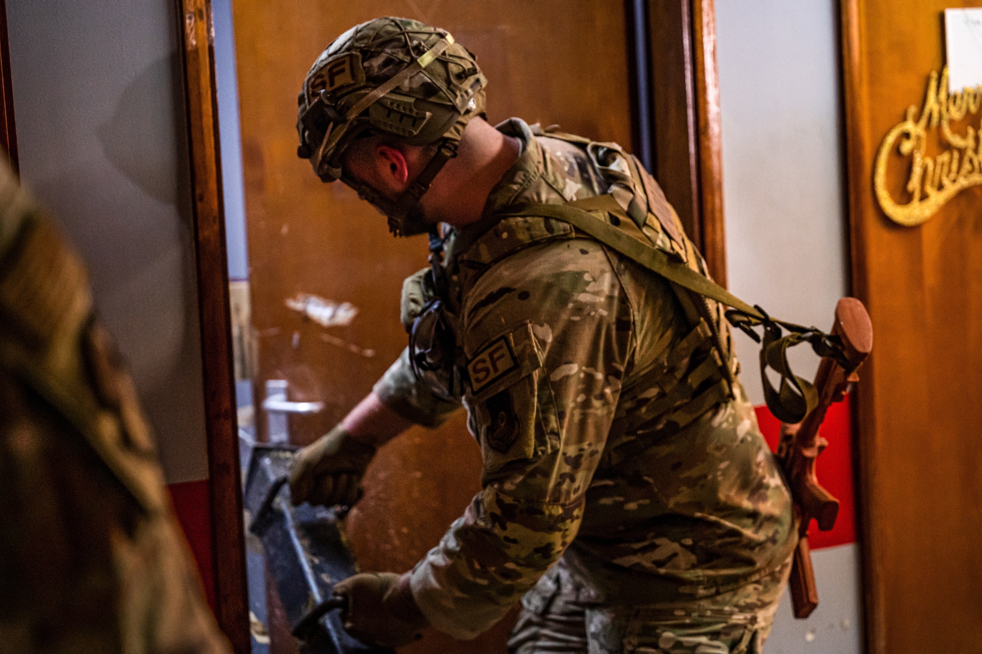 A defender from the 380th Expeditionary Security Forces Squadron uses a battering ram on a door to test and hone their forced entry tactics, techniques, and practices at Al Dhafra Air Base, United Arab Emirates, March 19, 2023. Defenders trained alongside 380th Expeditionary Civil Engineer Squadron firefighters and EOD Airmen to complete the realistic on-the-job training, using the unique opportunity of a location to train on to the full capacity. (U.S. Air Force photo by Staff Sgt. Sabatino DiMascio)