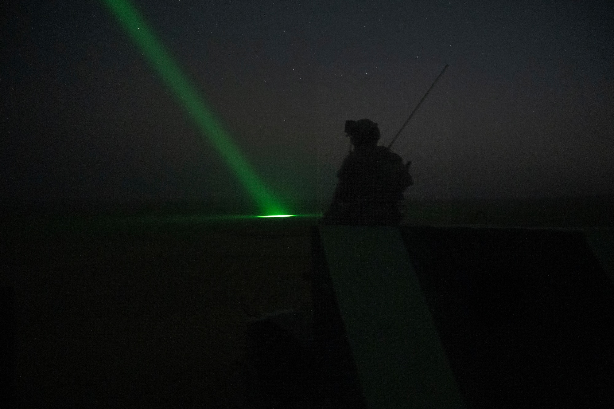 A U.S. Air Force tactical air control party Airman from the 82nd Expeditionary Air Support Operation Squadron watches as an AC-130 "Green Beam" marks the location of danger close for various weapons at Udairi Range, Kuwait, March 14, 2023.