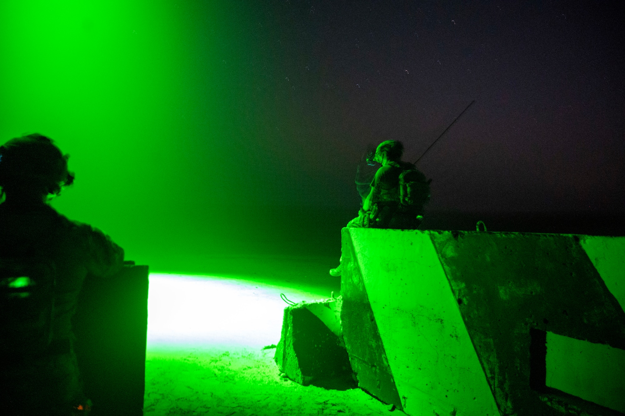 A U.S. Air Force tactical air control party Airman from the 82nd Expeditionary Air Support Operation Squadron watches as an AC-130 "Green Beam" marks the location of danger close for various weapons at Udairi Range, Kuwait, March 14, 2023.