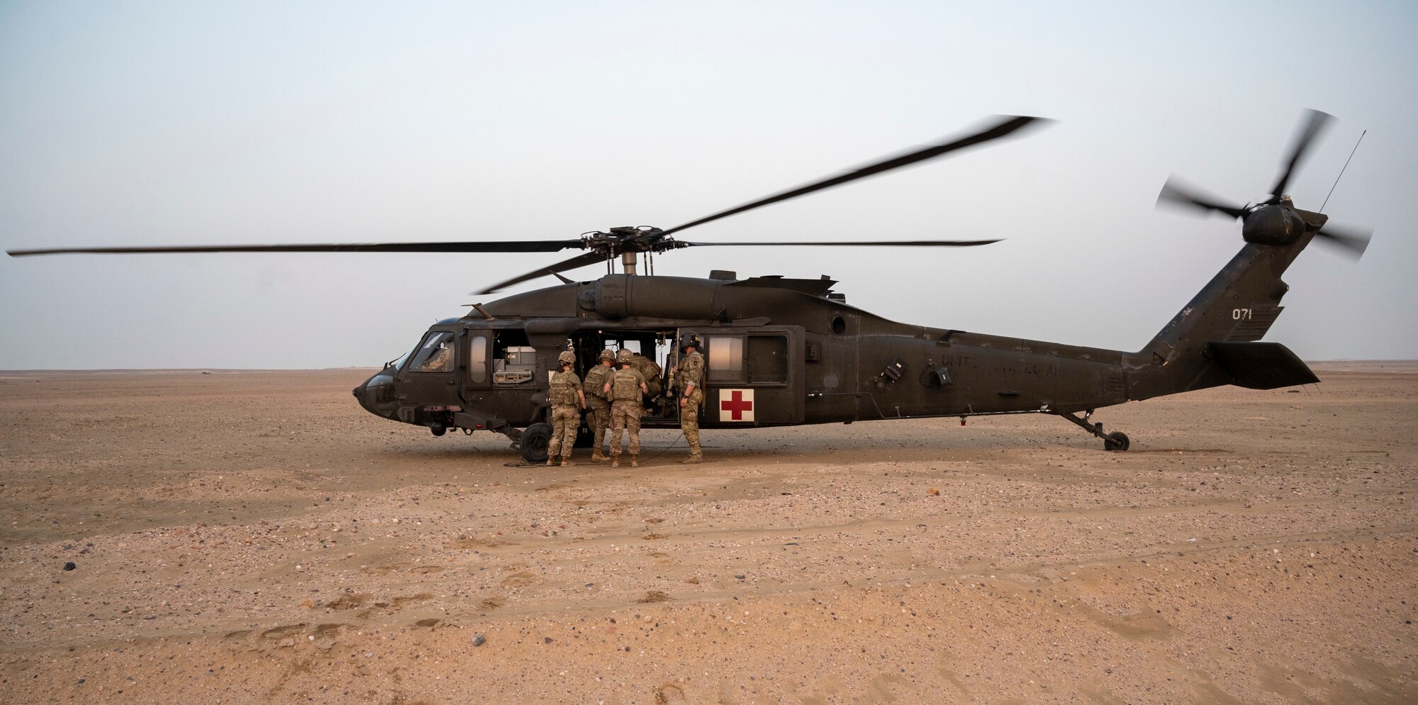 U.S. Army Soldiers offload a patient from a UH-60 Blackhawk helicopter during training at Udairi Range, Kuwait, March 14, 2023
