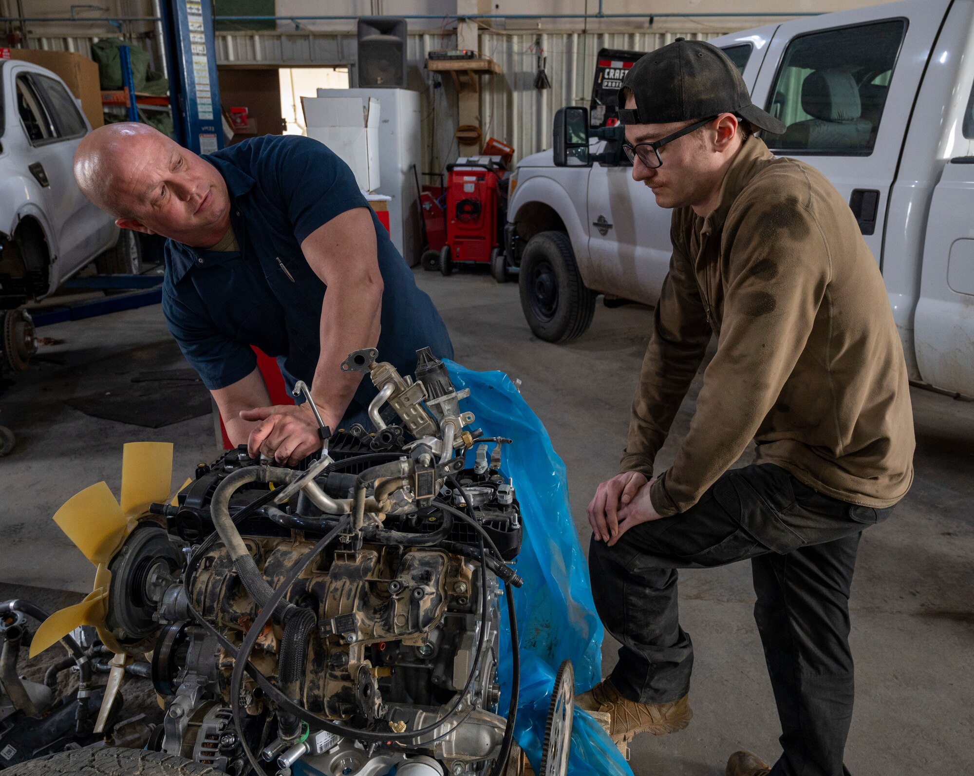 U.S. Air Force Airman 1st Class William Glendenning, Right, and U.S. Air Force Tech Sgt. Jeffery Burch, Left, 386th Expeditionary Logistics Readiness Squadron vehicle management specialists, fix an engine at Ali Al Salem Air Base, Kuwait, March 8, 2023.