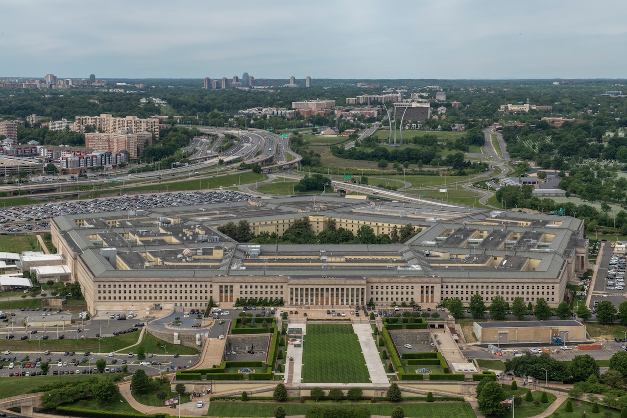 A five-sided building sits amidst green space, parking lots and highways.