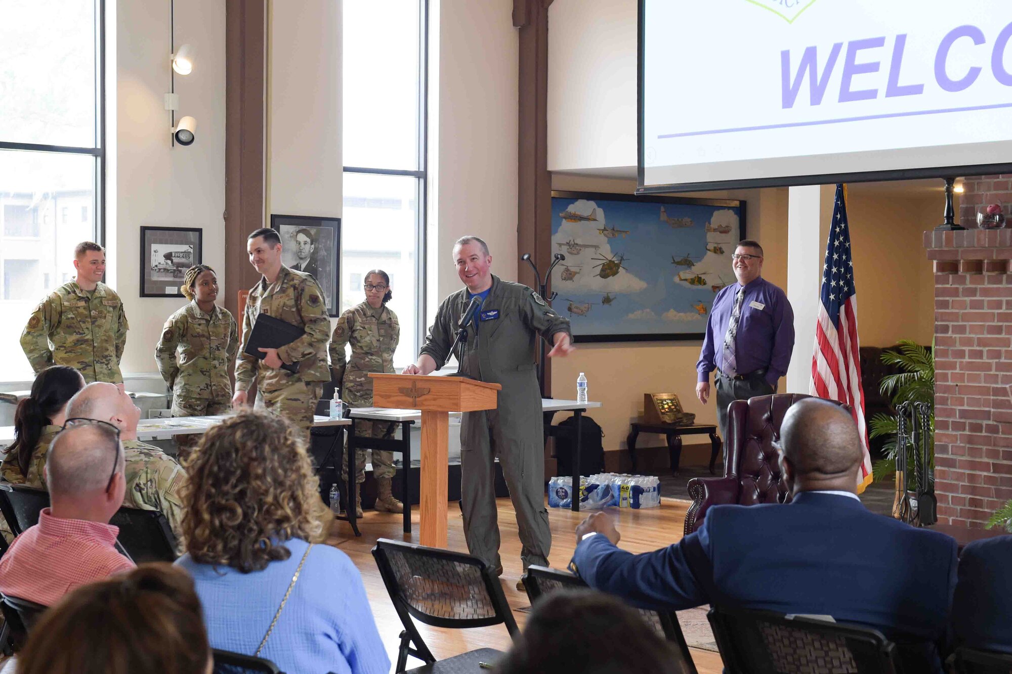 A photo of an Airman speaking at an event.