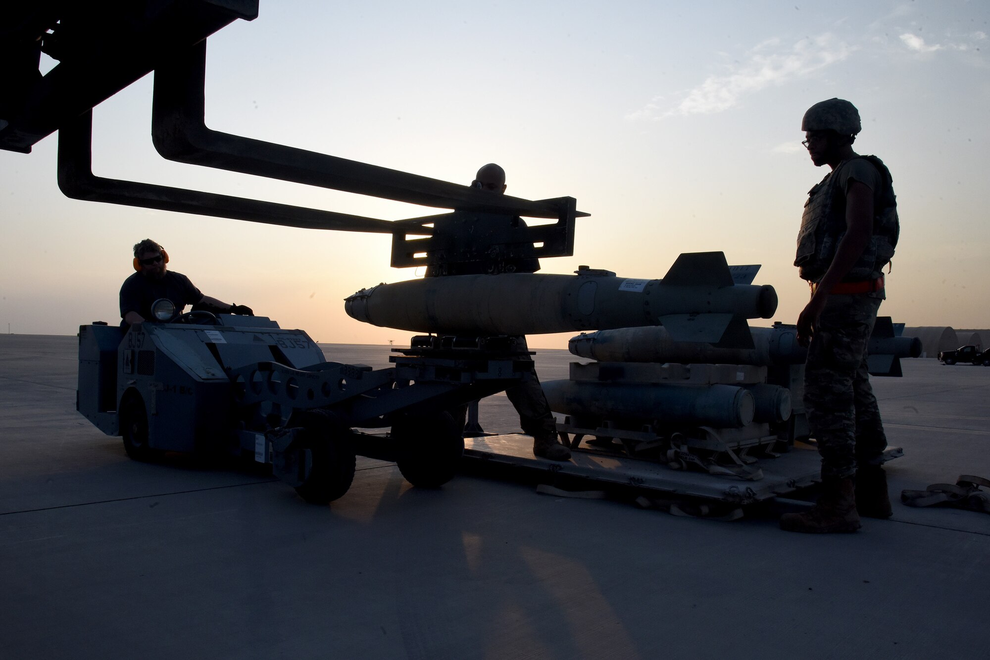 U.S. Air Force Senior Airman Christian Garner (right), 380th Expeditionary Maintenance Squadron AMMO technician, helps Amentum Contractors with the 62nd Expeditionary Attack Squadron load a dummy munition during Operation Agile Spartan 4 at Al Dhafra Air Base, United Arab Emirates, March 10, 2023. Operation Agile Spartan 4 was a Multi-Capable Airman and Agile Combat Employment exercise held at several bases across the U.S. Air Force Central Command to test and validate new capabilities in the field. (U.S. Air Force photo by Tech. Sgt. Chris Jacobs/released)