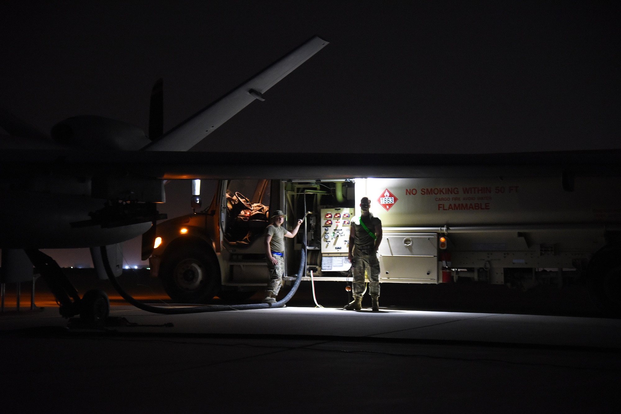 U.S. Air Force airmen assigned to the 380th Expeditionary Maintenance Squadron fuels management flight, refuel a U.S. Air Force MQ-9 Reaper during Operation Agile Spartan 4 at Al Dhafra Air Base, United Arab Emirates, March 10, 2023. Multi-Capable Airman Team 1 tested their accumulated skills acquired from several weeks of instruction and practice to execute Agile Combat Employment concepts at Al Dhafra AB.  (U.S. Air Force photo by Tech. Sgt. Chris Jacobs/released)