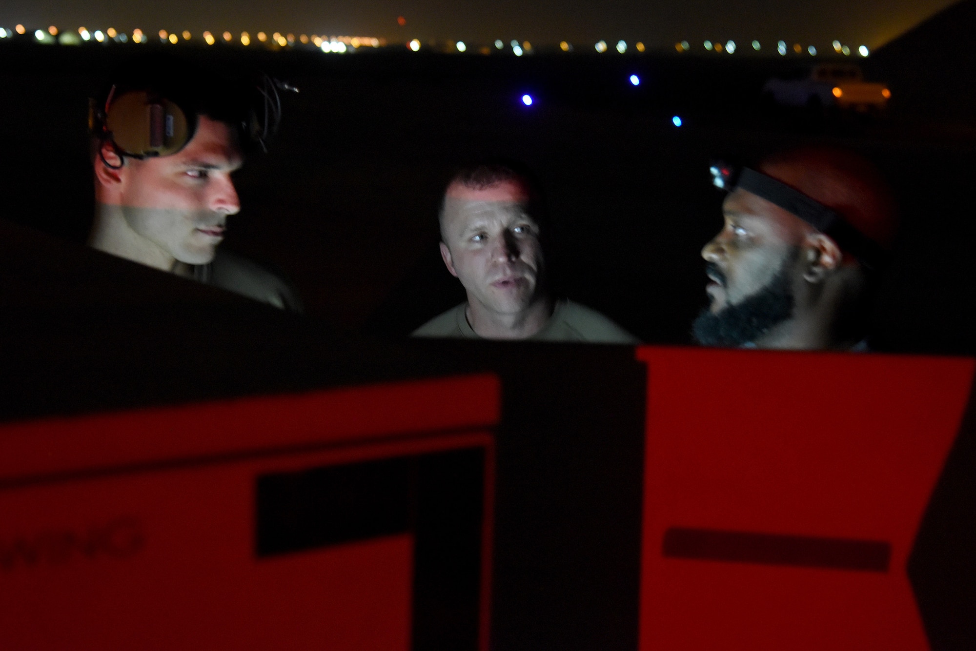 U.S. Air Force Staff Sgt. Gage Robinson (left), Multi-Capable Airman Team 1 member, goes over a pre-flight checklist for a U.S. Air Force MQ-9 Reaper with U.S. Air Force Senior Master Sgt. John Whitfield (center), Multi-Capable Airman Team 1 senior enlisted leader, and Omoro Christian, 62nd Expeditionary Attack Squadron contractor, at Al Dhafra Air Base, United Arab Emirates, March 10, 2023. MCA represents a mindset and cultural shift away from traditional, large force packages of highly specialized teams towards smaller-footprint, multidisciplinary teams able to provide combat support with the skills and resources at hand. (U.S. Air Force photo by Tech. Sgt. Chris Jacobs/released)