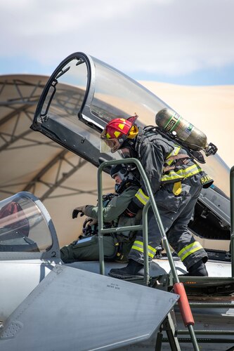U.S. Air Force Tech Sgt. Nicholas Harrington, a 386th Civil Engineer Squadron firefighter, extracts a pilot from an aircraft as part of a demonstration during Media Day at Ali Al Salem Air Base, Kuwait, March 21, 2023.