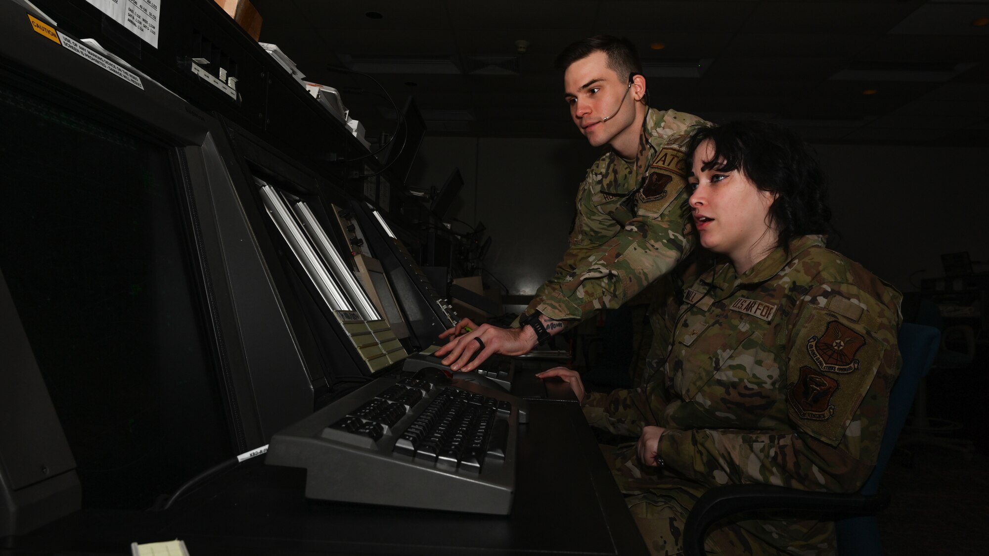 U.S. Air Force Senior Airman Tristian Horne, 509th Operations Support Squadron airfield operations system specialist, left and Airman AmberRose Wall, 509th Operations Support Squadron Air Traffic Control apprentice, watches the radar display monitor at Whiteman Air Force Base, Mo., March 13, 2023. The monitor allows them to see aircraft within the airspace so they can coordinate aircraft landing at the airport and leaving the airport. (U.S. Air Force photo by Airman 1st Class Hailey Farrell)