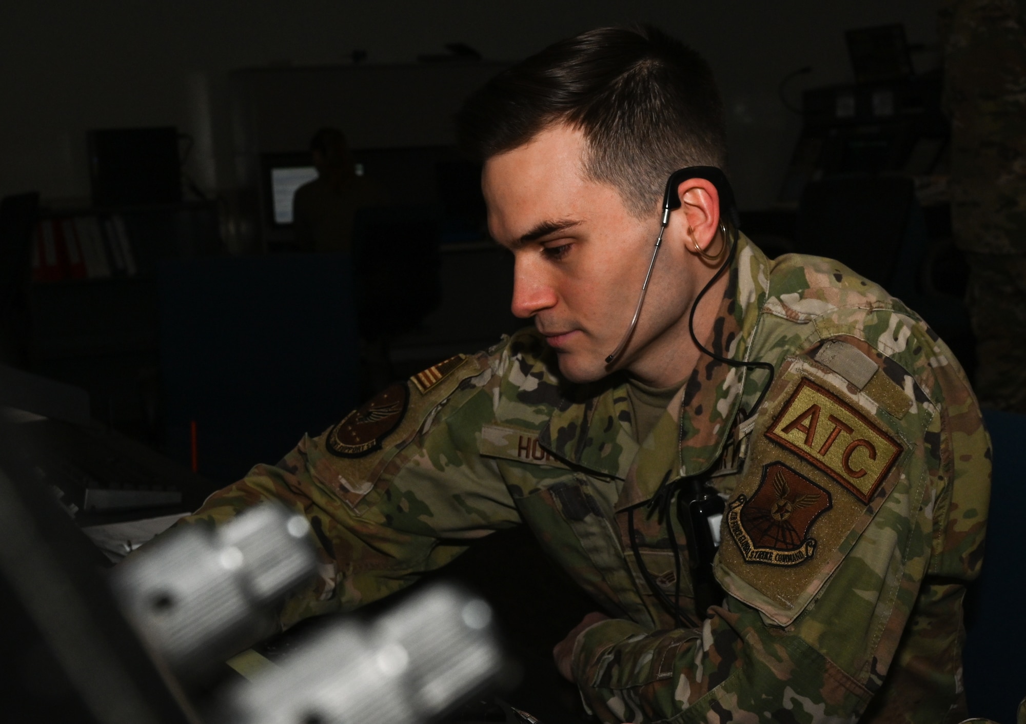 U.S. Air Force Senior Airman Tristian Horne, 509th Operations Support Squadron airfield operations systems specialist, uses the headset and transmitter to speak to aircraft at Whiteman Air Force Base, Mo., March 13th 2023. Radar Approach Control coordinates with incoming aircraft and then relays their location to the Air Traffic Control tower. (U.S. Air Force photo by Airman 1st Class Hailey Farrell)