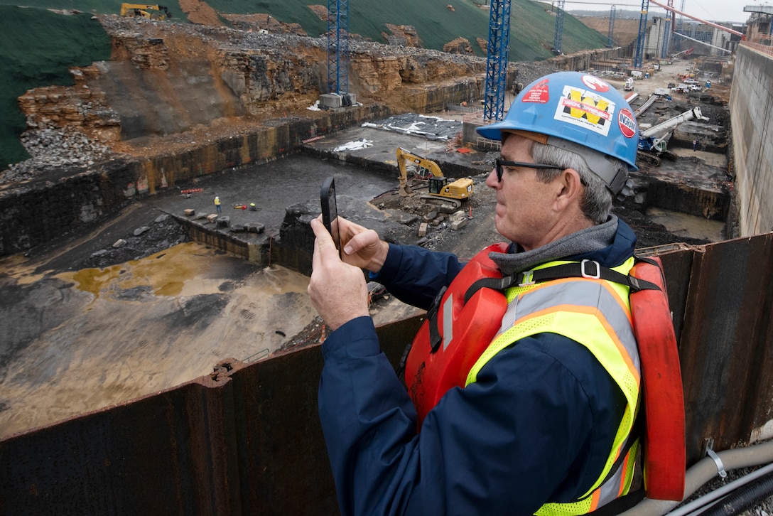 Jason Adams, Inland Marine Service chief executive officer, takes photos with his phone of the Kentucky Lock Addition Project during a stakeholder tour to see ongoing construction of the downstream section of the lock chamber. The Nashville District engaged with stakeholders March 22, 2023, to provide an update on the important navigation project and to promote partnerships and communication. (USACE Photo by Lee Roberts)