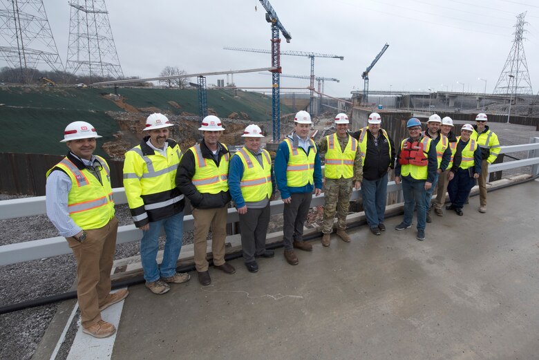 U.S. Army Corps of Engineers Nashville District officials and stakeholders pose for a group photo on top of the coffer dam during a tour of the active Kentucky Lock and Kentucky Lock Addition Project on the Tennessee River in Grand Rivers, Kentucky. The Nashville District engaged with stakeholders March 22, 2023, to provide an update on the important navigation project and to promote partnerships and communication. (USACE Photo by Lee Roberts)
