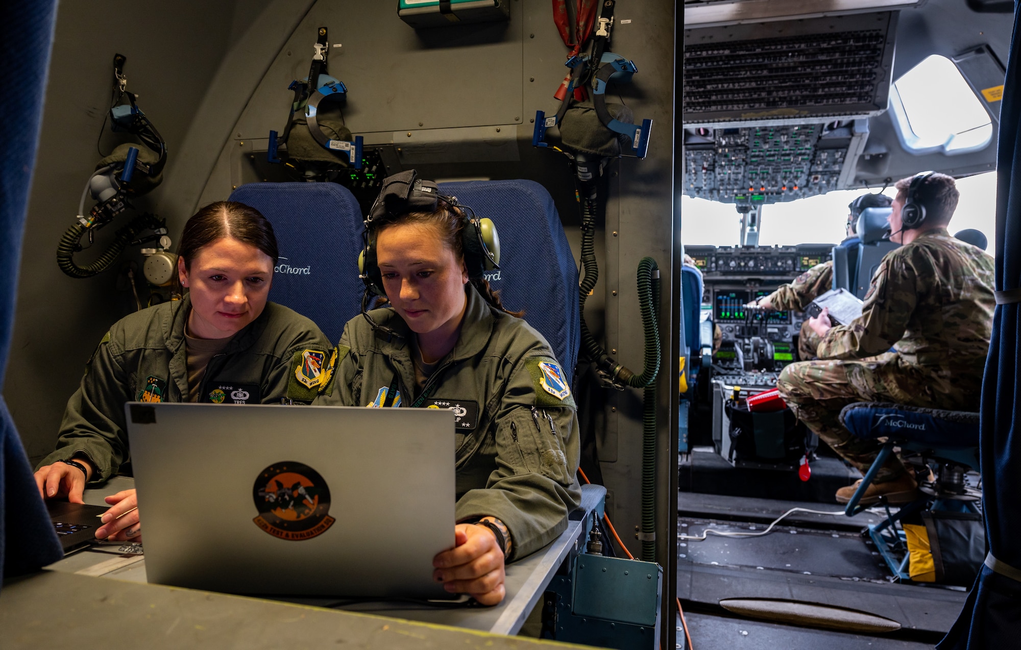U.S. Air Force Staff Sgt. Hannah Fisk, left and Tech. Sgt. Megan Wolfe, Weapons Directors with the 422nd Test and Evaluation Squadron, Command and Control (C2) Division, operate inside the cockpit of a C-17 Globemaster III during Black Flag 23-1 at Nellis Air Force Base, Nevada, Feb. 23, 2023. This operation was accomplished by the combined effort between the C2 teams both on the ground and on the C-17 as they shared data real time to facilitate live operations. (U.S. Air Force photo by Airman 1st Class Josey Blades)