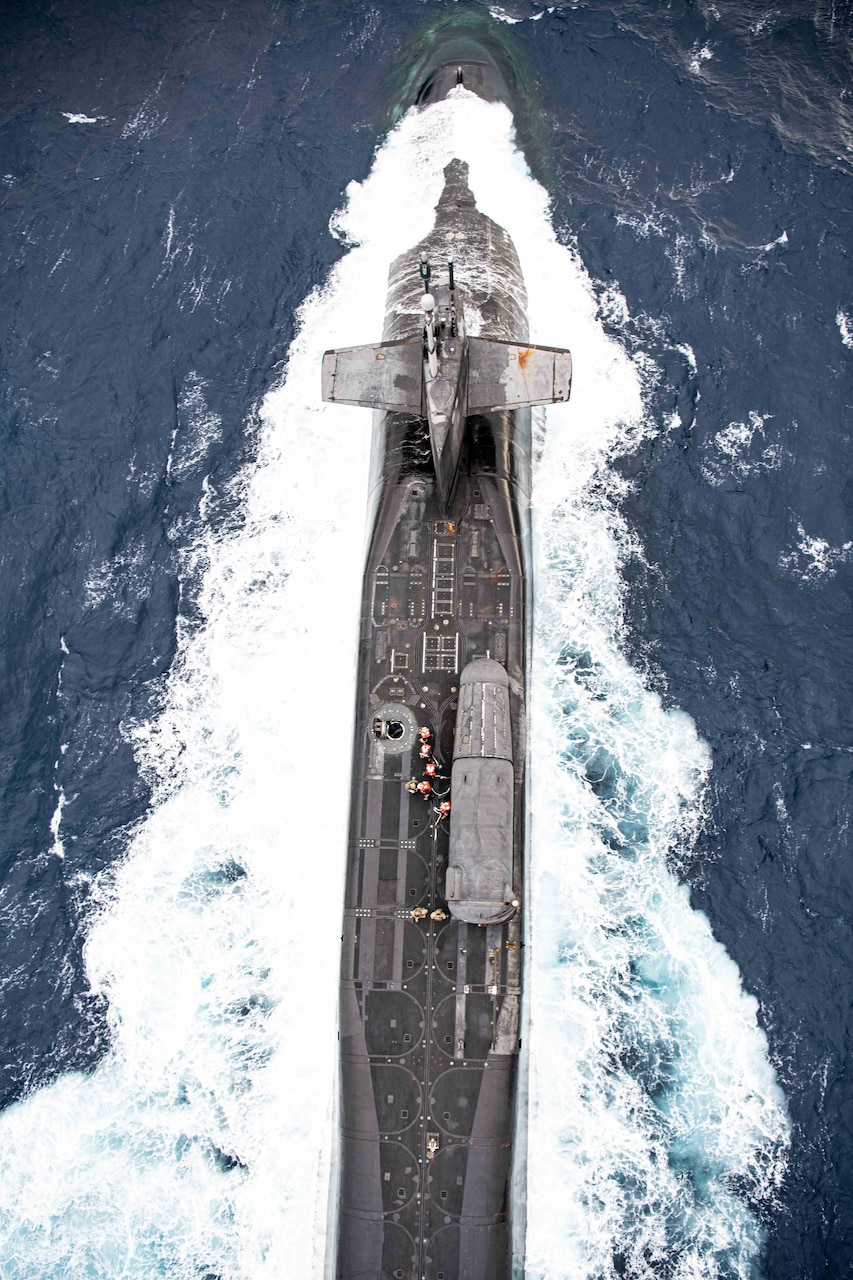 A submarine moves through water as seen from above.