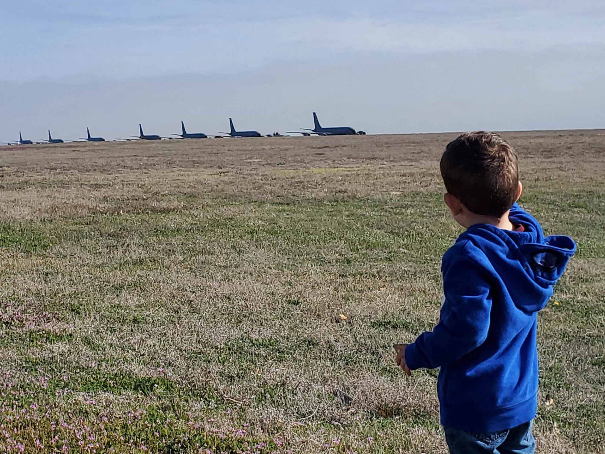 A child looks toward KC-135 Stratotankers taxiing on the Altus Air Force Base, Oklahoma runway, March 24, 2023 during a large force exercise. Many spectators came out to view the exercise, including Airmen, members of the community and military dependents. (U.S. Air Force photo by Master Sgt. Nathan Allen)