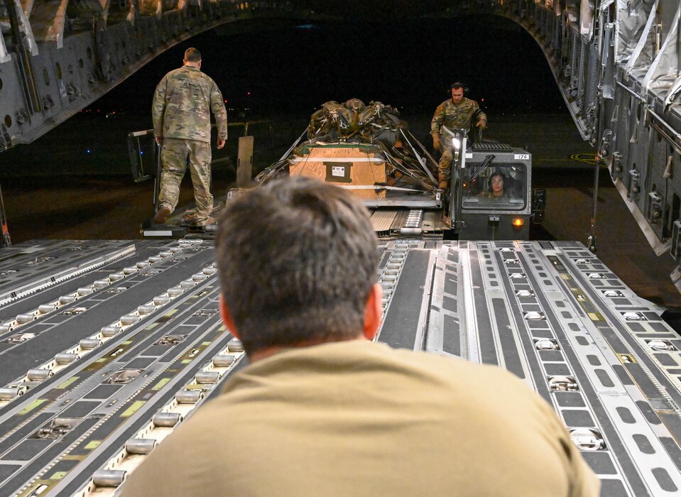 U.S. Air Force Airmen work together to guide a Tunner 60k loader near the back of a C-17 Globemaster III during a large force exercise at Altus Air Force Base, Oklahoma, March 24, 2023. The 97th Logistics Readiness Squadron delivers agile logistics in support of the Air Force’s sole C-17, KC-135 Stratotanker and KC-46 Pegasus formal training units. (U.S. Air Force photo by Senior Airman Trenton Jancze)