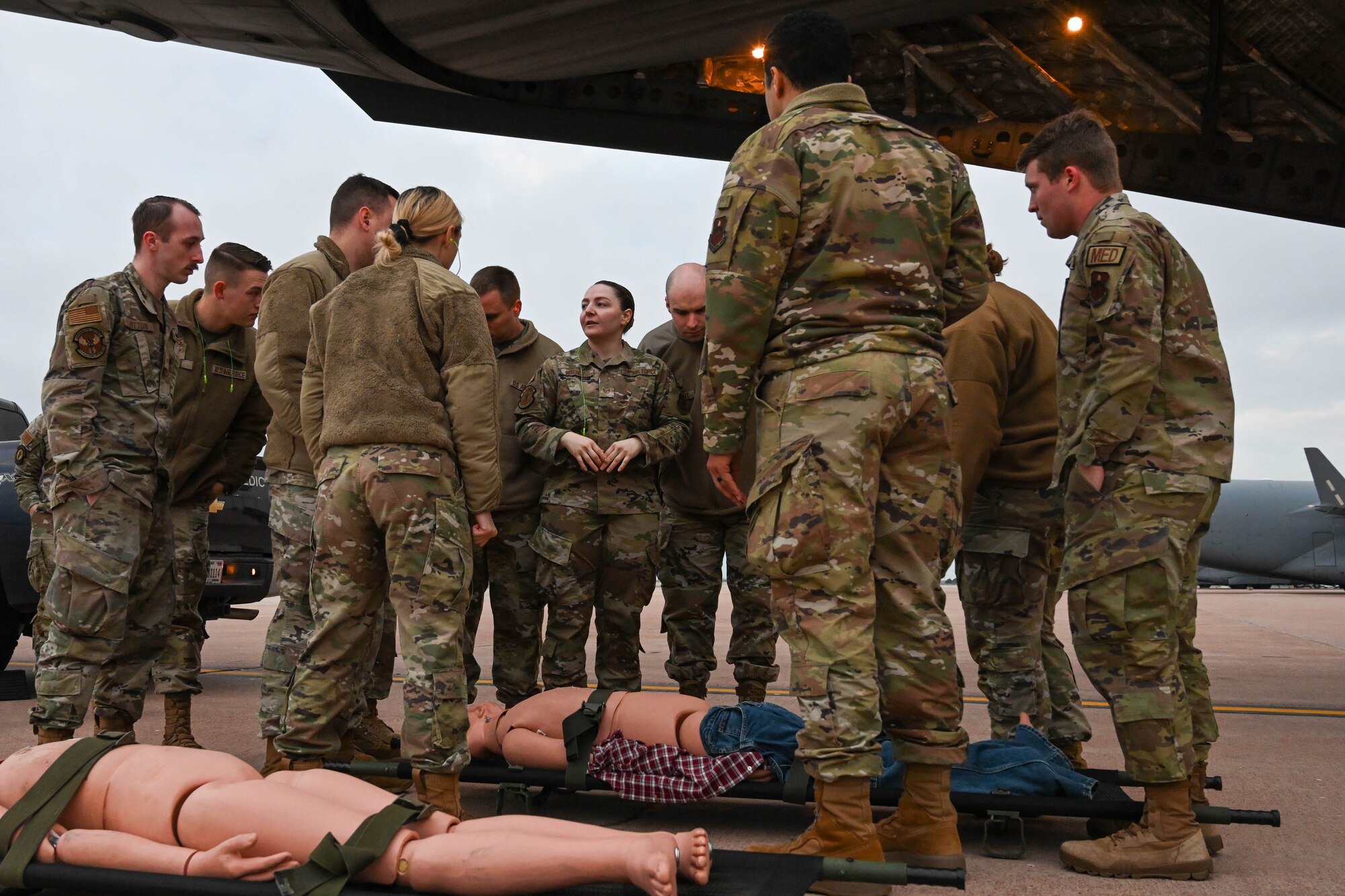 U.S. Air Force Staff Sgt. Riley Ditnoy, 97th Medical Group (MDG) tactical combat casualty care coordinator, talks to her colleagues before carrying manikins onto a C-17 Globemaster III at Altus Air Force Base, Oklahoma, March 24, 2023. The 97th MDG provides healthcare to about 6,400 beneficiaries and 2,000 aircrew students annually. (U.S. Air Force photo by Senior Airman Trenton Jancze)