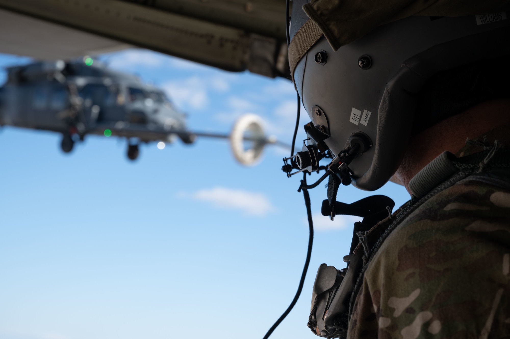 U.S. Air Force Master Sgt. David Williams, a Loadmaster assigned to the 102nd Rescue Squadron, New York Air National Guard, watches as an HH-60G Pave Hawk assigned to the 101st Rescue Squadron, New York Air National Guard conducts air-to-air refueling during Red Flag-Nellis 23-2 at Nellis Air Force Base, Nevada, March 16, 2023.