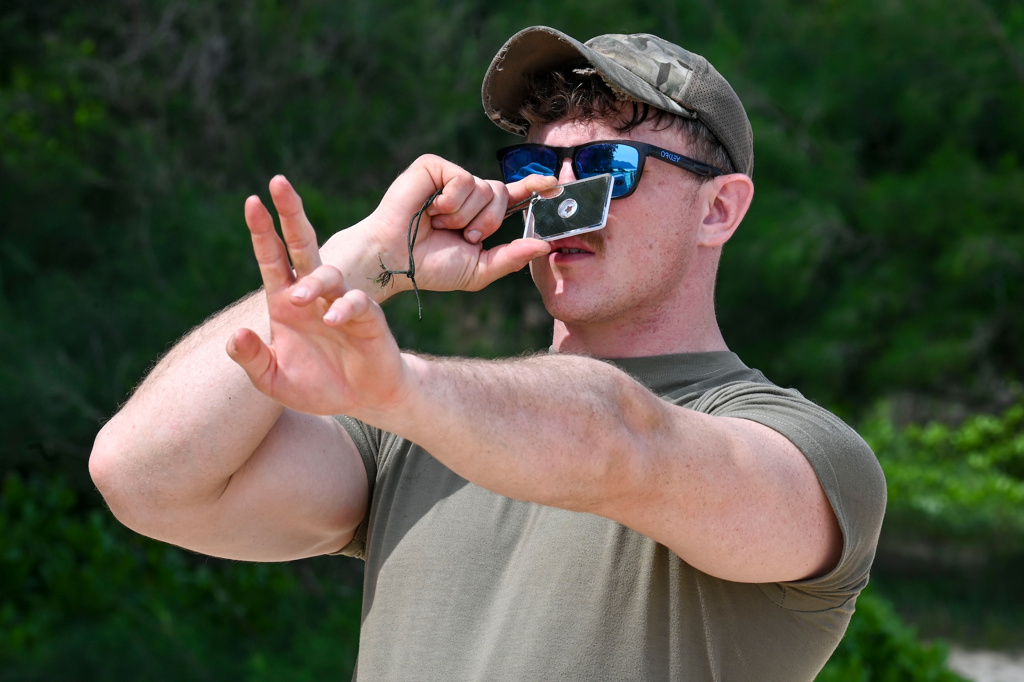 U.S. Air Force Staff Sgt. Daniel Hukill, 92nd Aircraft Maintenance Squadron flying crew chief, learns how to signal aircraft in case of emergencies during a simulated isolation survival scenario at Bellows Air Force Station, Hawaii, Feb. 1, 2023. Survival training like this event, is essential to ensuring airmen are ready and capable for being isolated in different biomes. (U.S. Air Force photo by Airman 1st Class Haiden Morris)