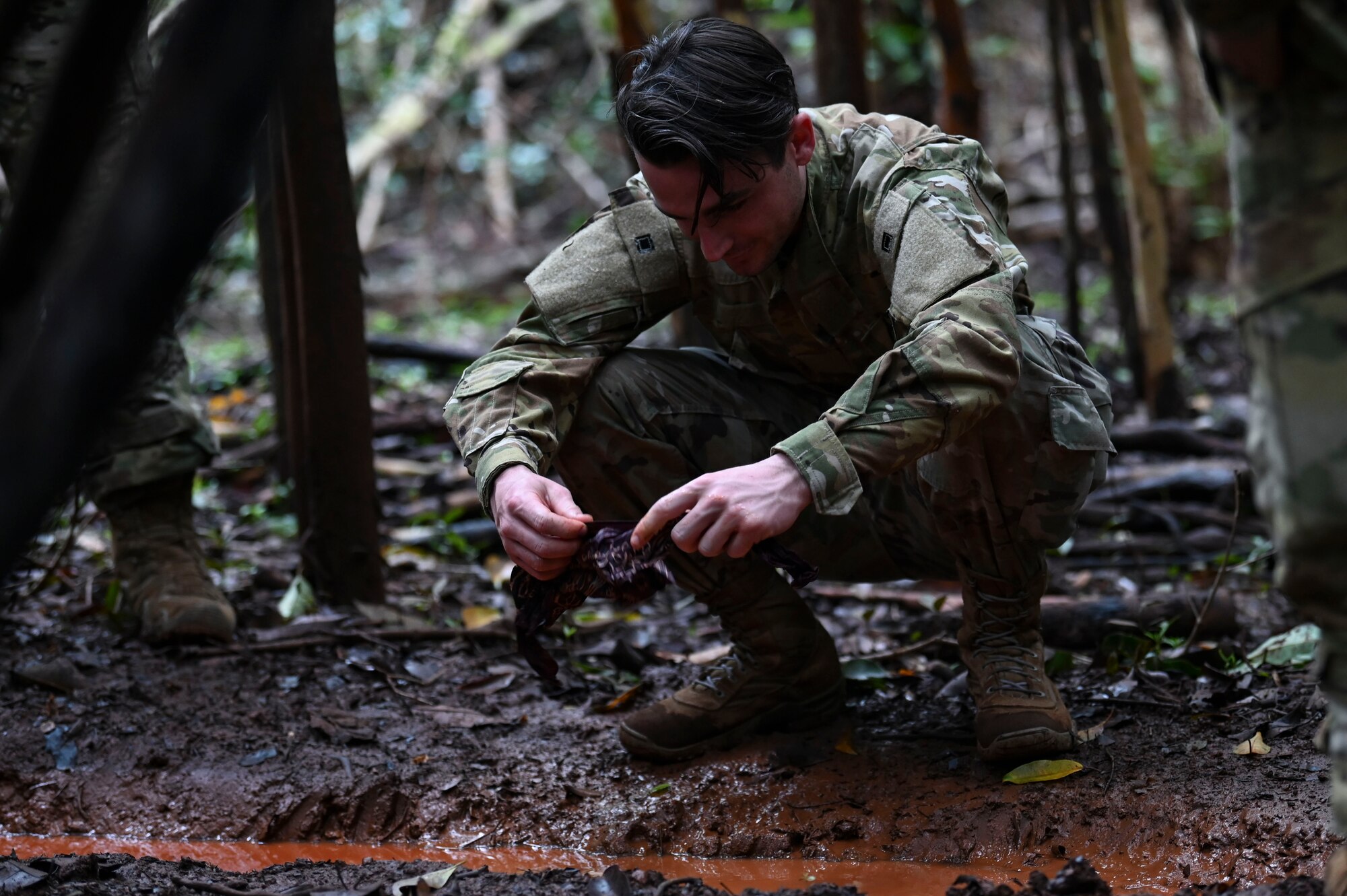 U.S. Air Force Senior Airman Blake Witzel, 92nd Aircraft Maintenance Squadron flying crew chief, analyzes water found on the jungle ground during a simulated isolation scenario near Bellows Air Force Station, Hawaii, Feb. 2, 2023. Survival training like this event, is essential to ensuring airmen are ready and capable for being isolated in different biomes. (U.S. Air Force photo by Airman 1st Class Haiden Morris)