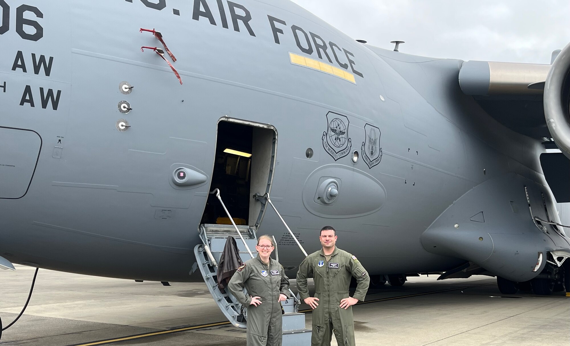 U.S. Air Force Master Sgt. Valerie Stephens, 517th Airlift Squadron operations superintendent, and a servicemember assigned to the 176th Wing, pose in front of a C-17 Globemaster III at Joint Base Elmendorf-Richardson, Alaska.