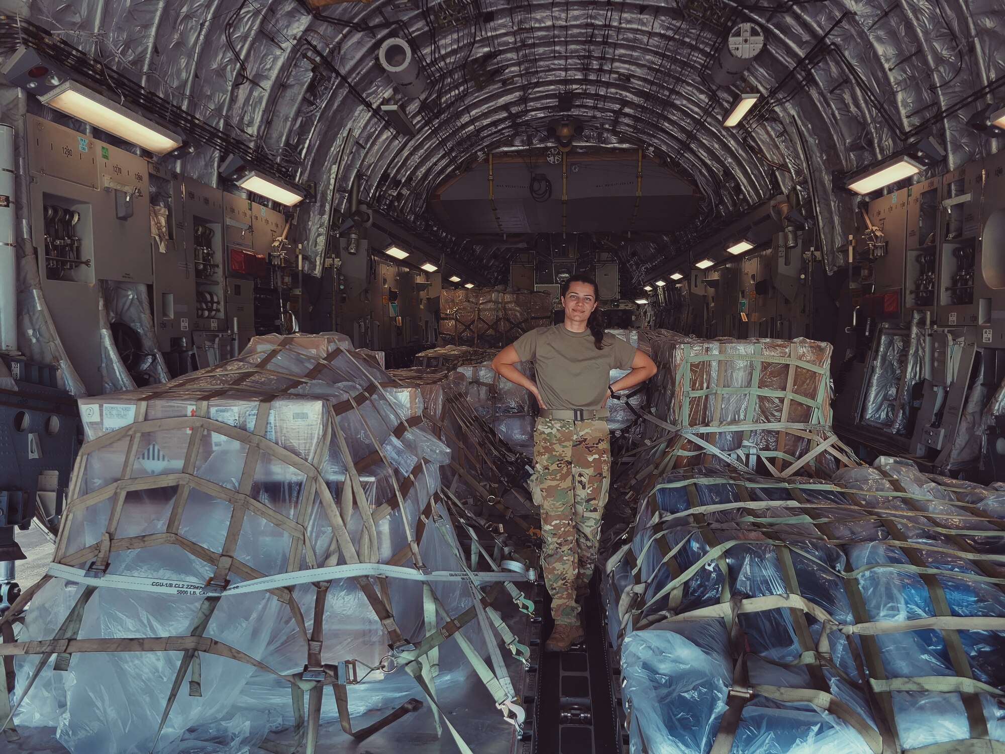 U.S. Air Force Airman 1st Class Elisabeth Wright, poses in front of cargo strapped inside of a C-17 Globemaster III at Joint Base Elmendorf-Richardson.