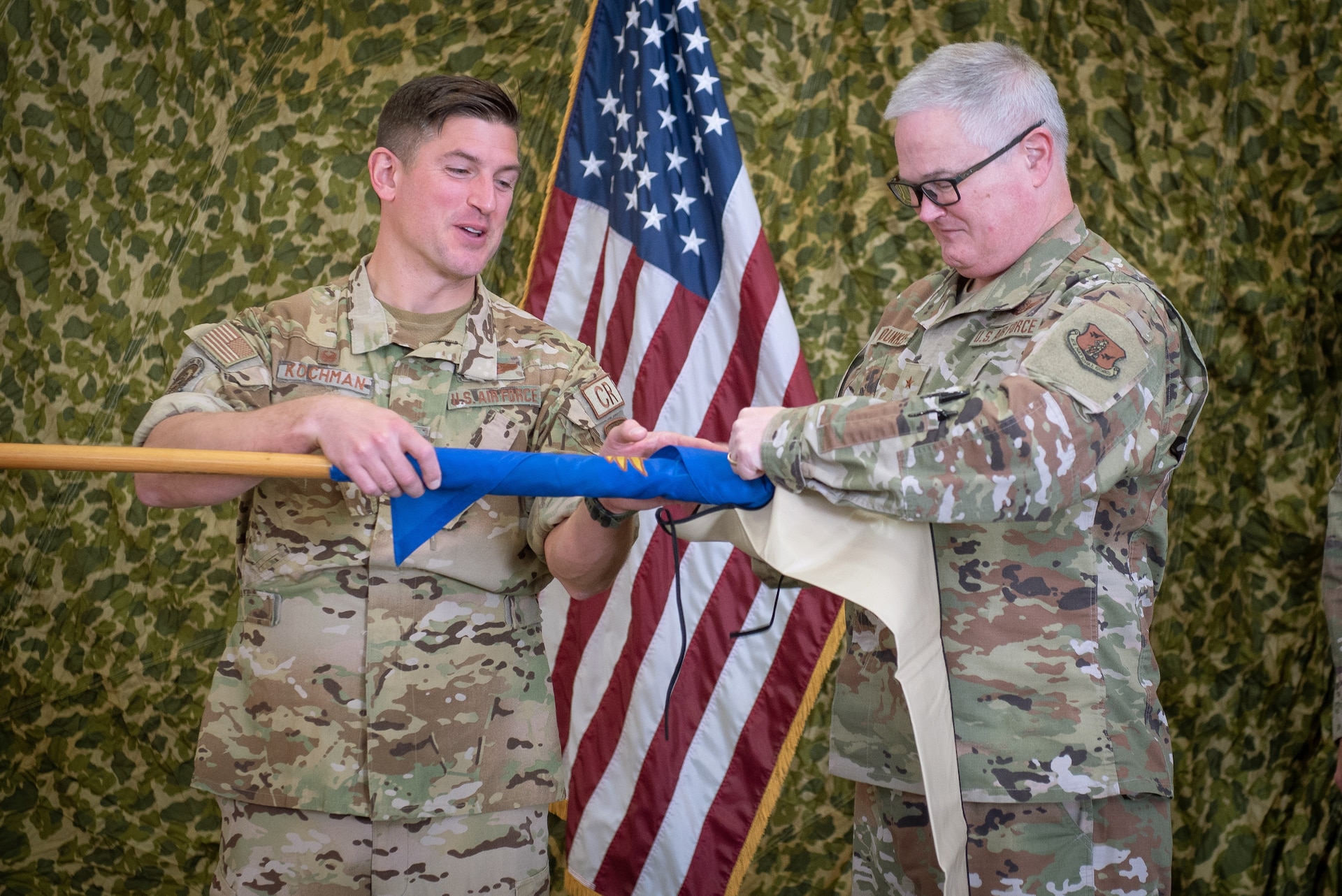 Brig. Gen. David J. Mounkes, right, assistant adjutant general for Air, sheathes a retired contingency response squadron guidon with the help of Maj. Andrew Kochman during a redesignation ceremony Oct. 16, 2022, at the Kentucky Air National Guard Base in Louisville, Ky. During the event, the 123rd Global Mobility Readiness Squadron was renamed the 123rd Contingency Response Support Squadron, and the 123rd Global Mobility Squadron was renamed the 123rd Contingency Response Squadron. (U.S. Air Force photo by Staff Sgt. Clayton Wear)
