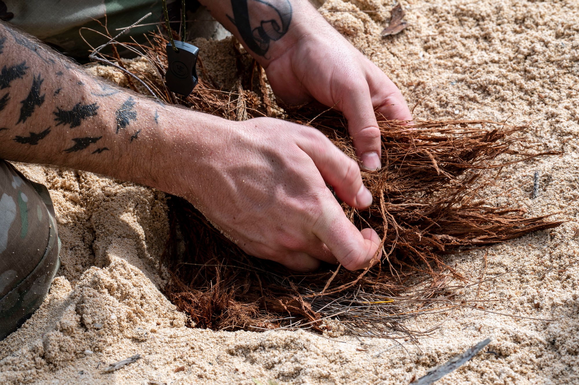U.S. Air Force Senior Airman Blake Witzel, 92nd Aircraft Maintenance Squadron flying crew chief, prepares a fire during a survival isolation scenario at Bellows Air Force Station, Hawaii, Feb. 1, 2023. Survival training like this event, is essential to ensuring our airmen ready and capable for being isolated in different biomes. (U.S. Air Force photo by Airman 1st Class Haiden Morris)