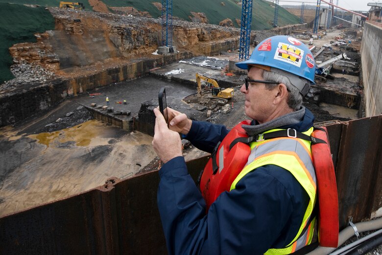 Jason Adams, Inland Marine Service chief executive officer, takes photos with his phone of the Kentucky Lock Addition Project during a stakeholder tour to see ongoing construction of the downstream section of the lock chamber. The Nashville District engaged with stakeholders March 22, 2023, to provide an update on the important navigation project and to promote partnerships and communication. (USACE Photo by Lee Roberts)