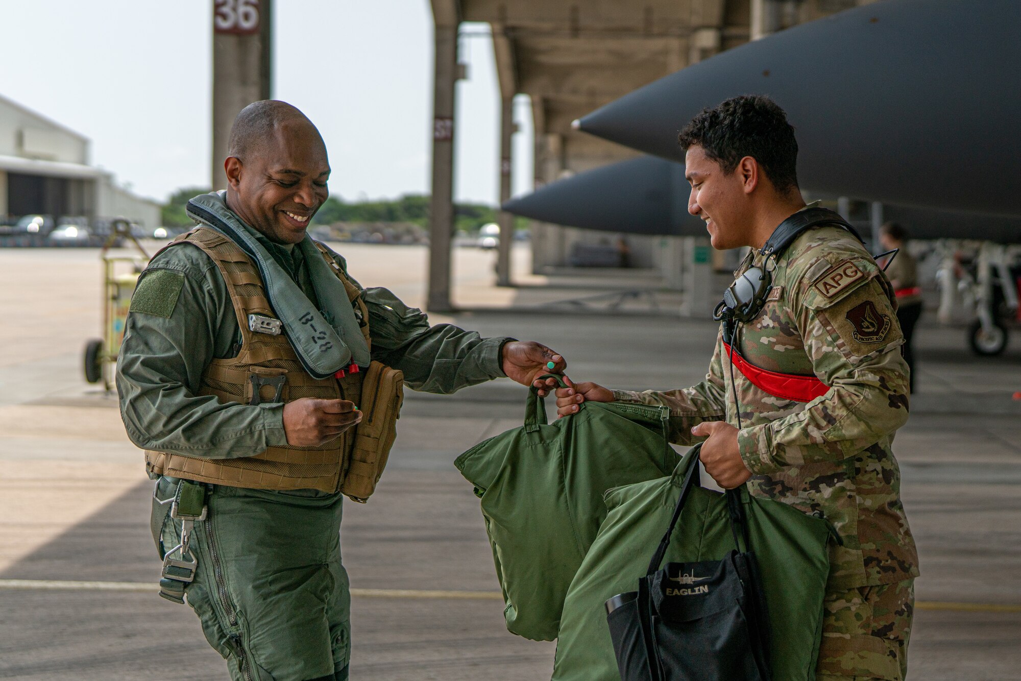 Airmen handle flight bags.